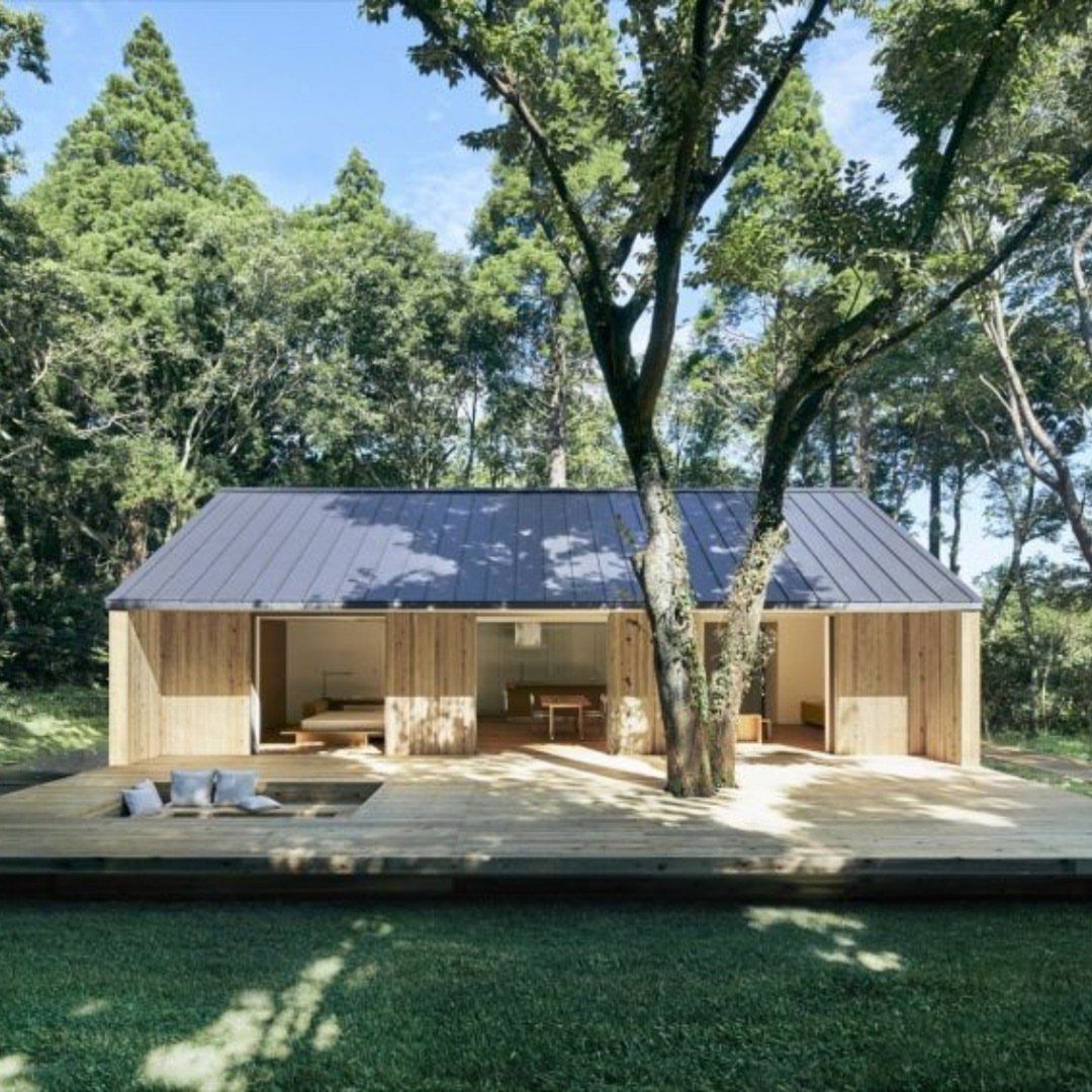 21 Backyard Deck Ideas For Any Size Space 21 Wooden cabin with a large deck featuring a sunken seating area with grey cushions.