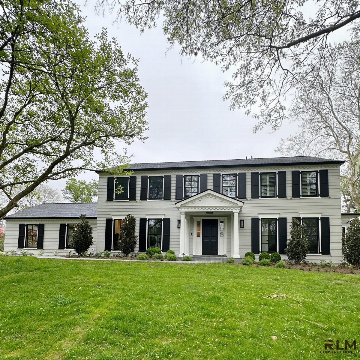 16 Black Modern Farmhouse Exterior Ideas With Photos 6 A large light gray two-story house with black shutters and a black front door.