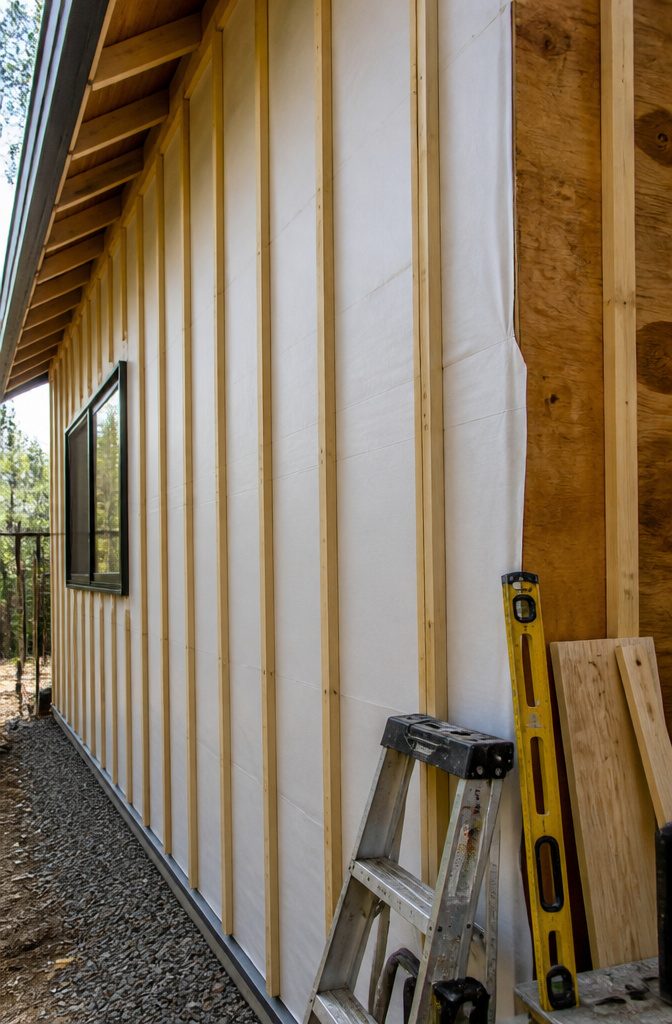 Exposed wall with furring strips and a weather-resistant barrier.