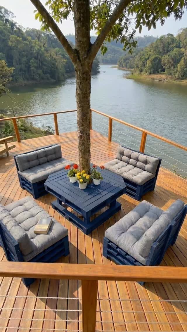 12 Deck Furniture Ideas: Layouts for Seating, Dining & Entertaining 6 Blue pallet lounge chairs with grey cushions arranged around a central coffee table on a wooden deck.