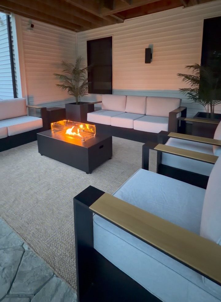 12 Deck Furniture Ideas: Layouts for Seating, Dining & Entertaining 5 Modern outdoor lounge area with a glowing fire pit table surrounded by grey cushioned seating.