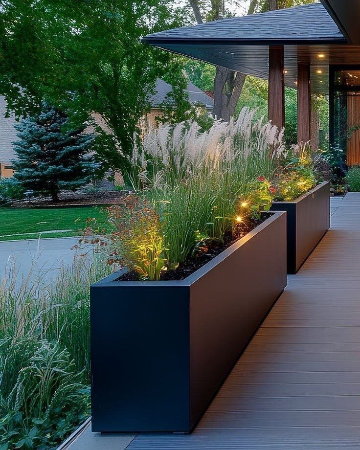 15 Decks and Porches Back Patio Ideas for Outdoor Living 3 Dark rectangular planter boxes with tall ornamental grasses on a light gray wooden deck.