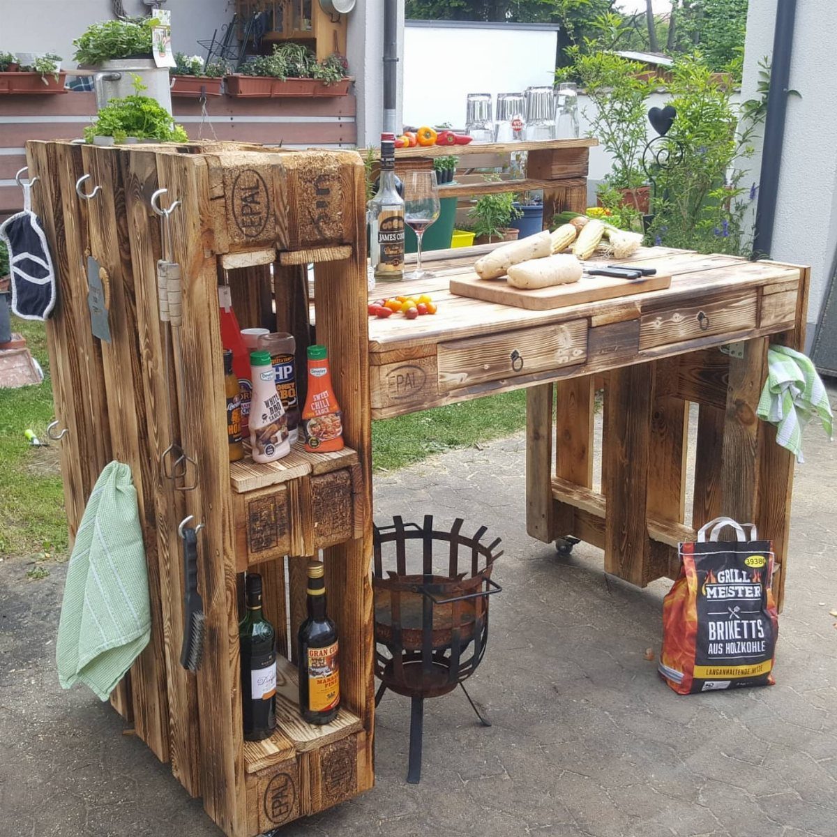 Pallet Grill Station: 7 Outdoor Builds from Cart to Kitchen 3 A rustic pallet grill station with a wooden countertop, shelving for bottles, and a small charcoal brazier.