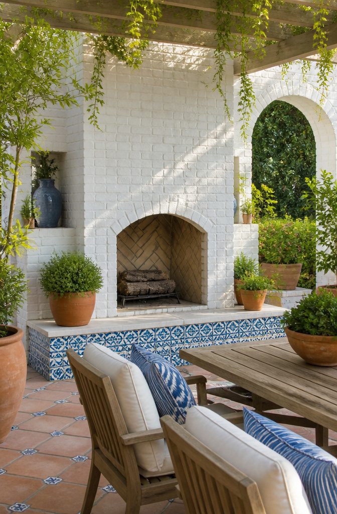Whitewashed brick fireplace with terracotta planters nearby.
